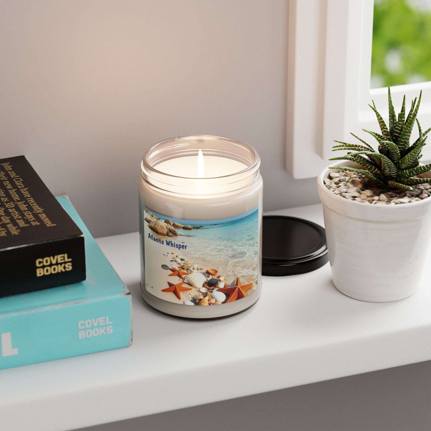 Scented Soy Candle Atlantis Whisper 9oz on shelf with plants and books, beach-inspired fragrance.
