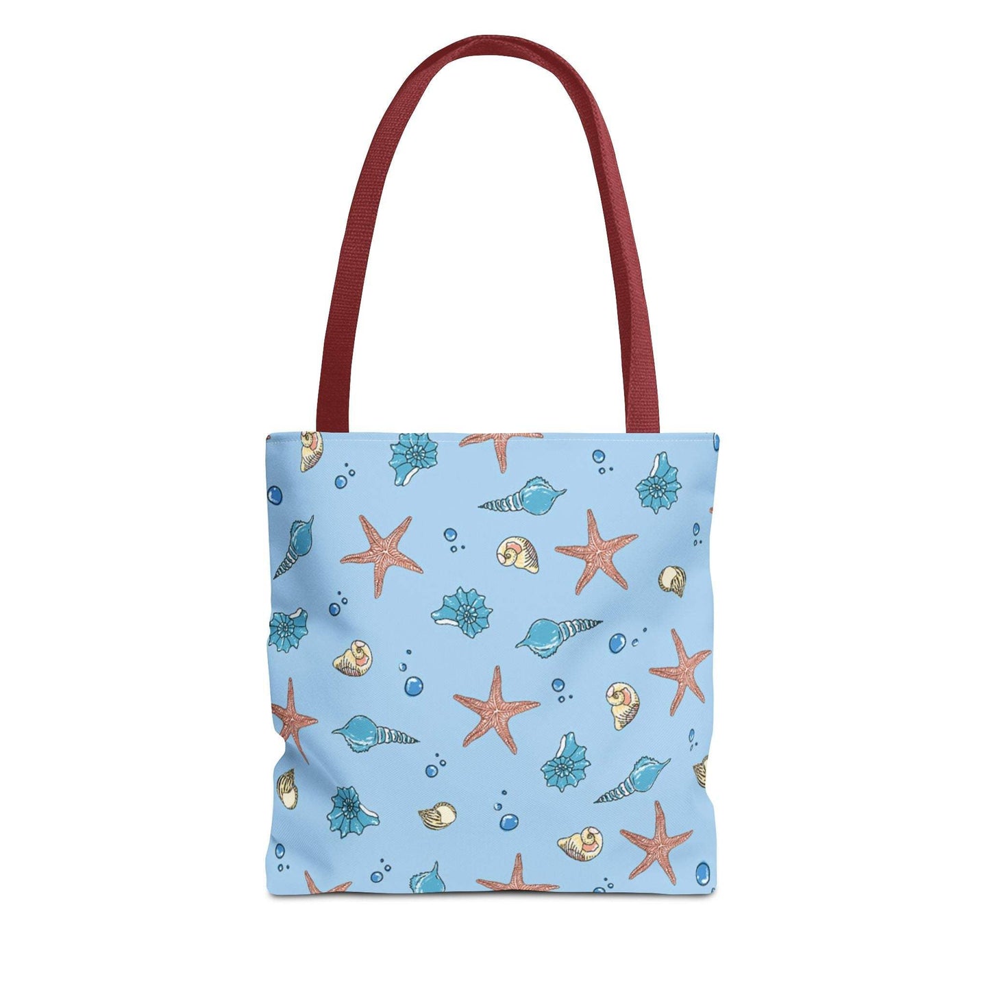 Beach tote bag with shell and starfish design, featuring ocean-themed patterns and red handles.