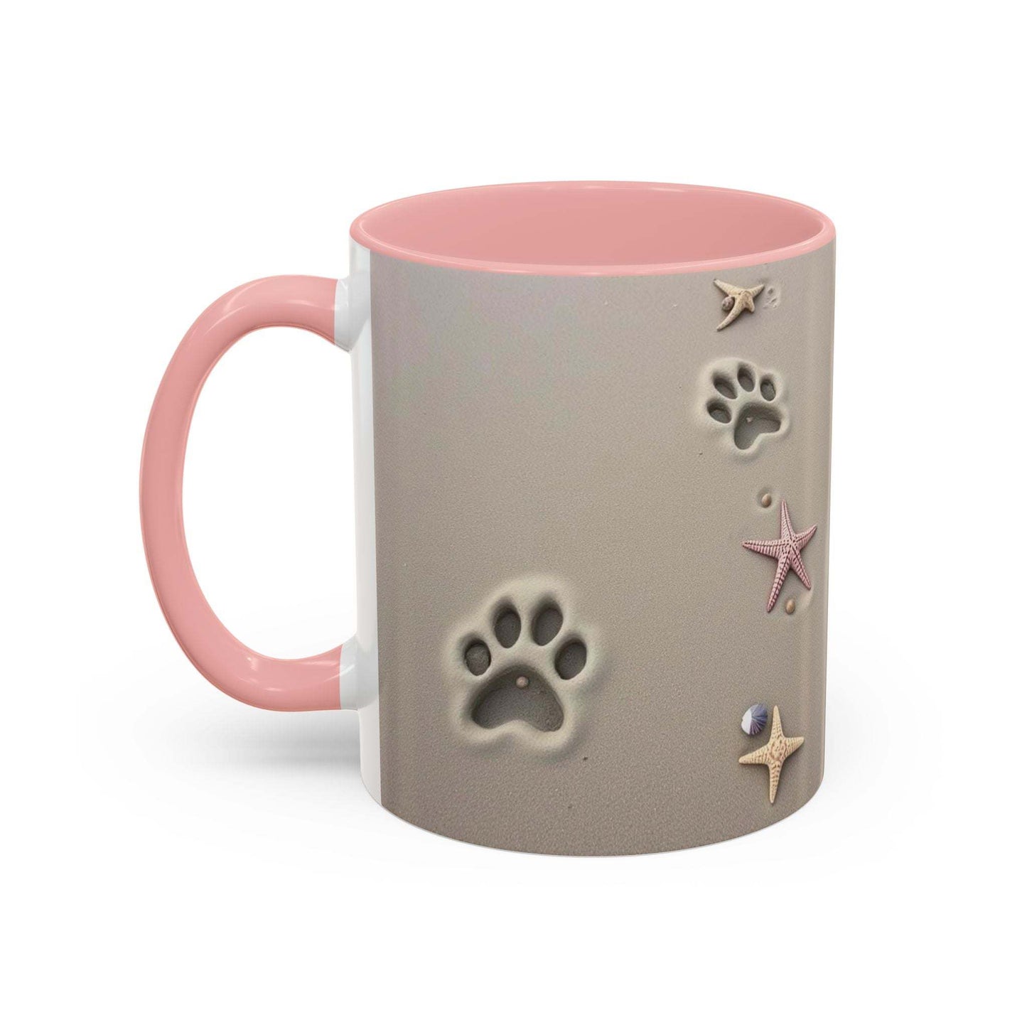 Nautical coffee mug with starfish and paw prints, pink handle, beach-themed design.