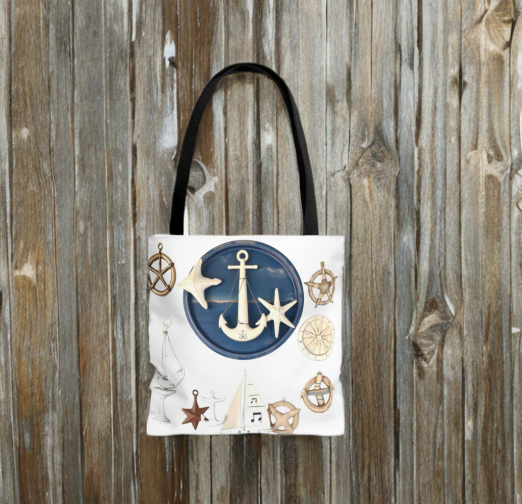 Nautical tote bag with anchor and star motif, black handles, wooden background.