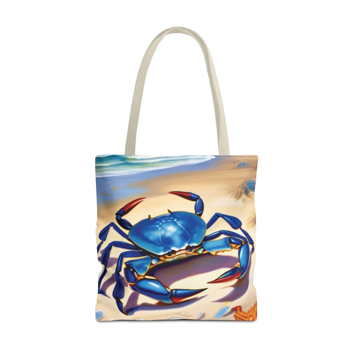 Ocean-inspired beach bag tote with blue crab design on sandy backdrop.