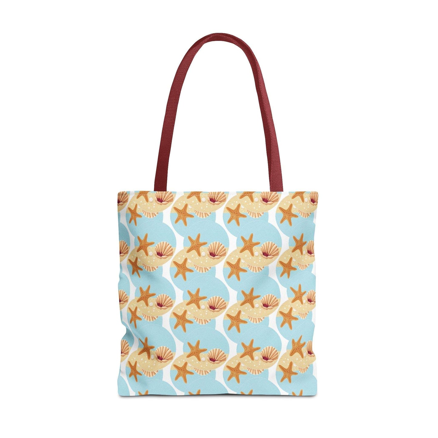 Seashell and starfish beach tote bag with coastal pattern and red handles.