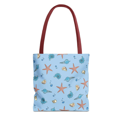 Beach tote bag with shell and starfish design, featuring ocean-themed patterns and red handles.