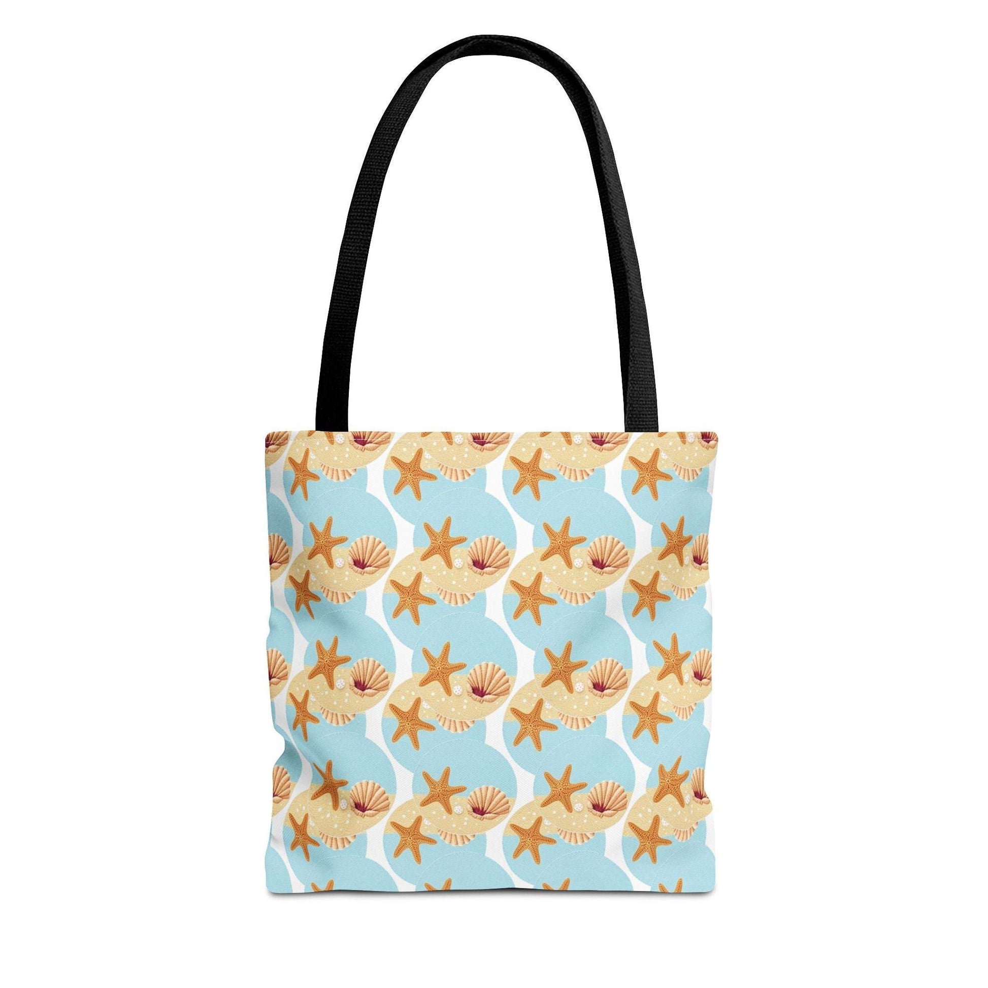 Seashell and starfish pattern beach bag with black handles on a light blue background.