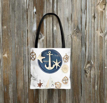 Nautical tote bag with anchor and star motif, black handles, wooden background.