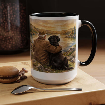 Man and Dog Watching Sunset ceramic mug with black interior and handle, featuring painted figures beside calm water